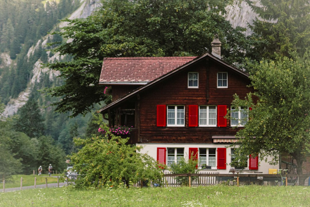 Maison de vacances en bois aux volets rouges dans une vallée de montagne